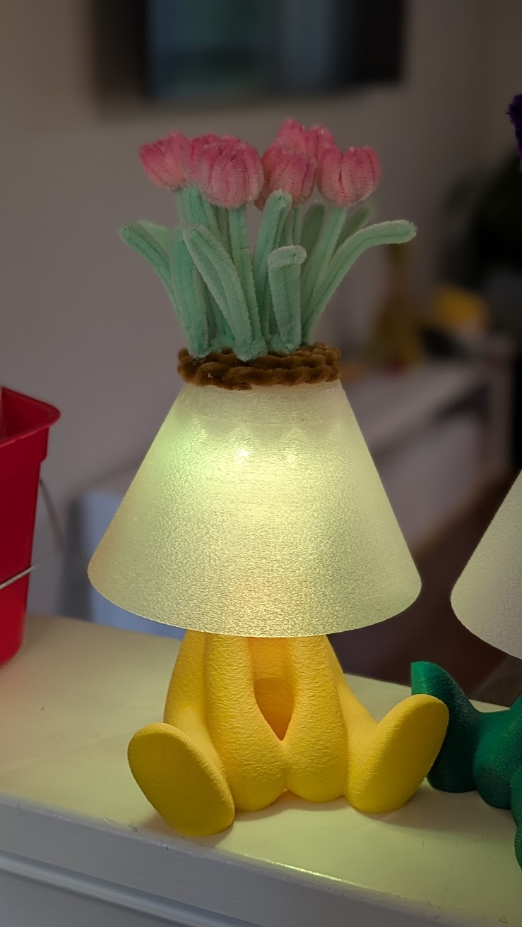 Yellow lamp with pink tulip pipe cleaner flowers lit up